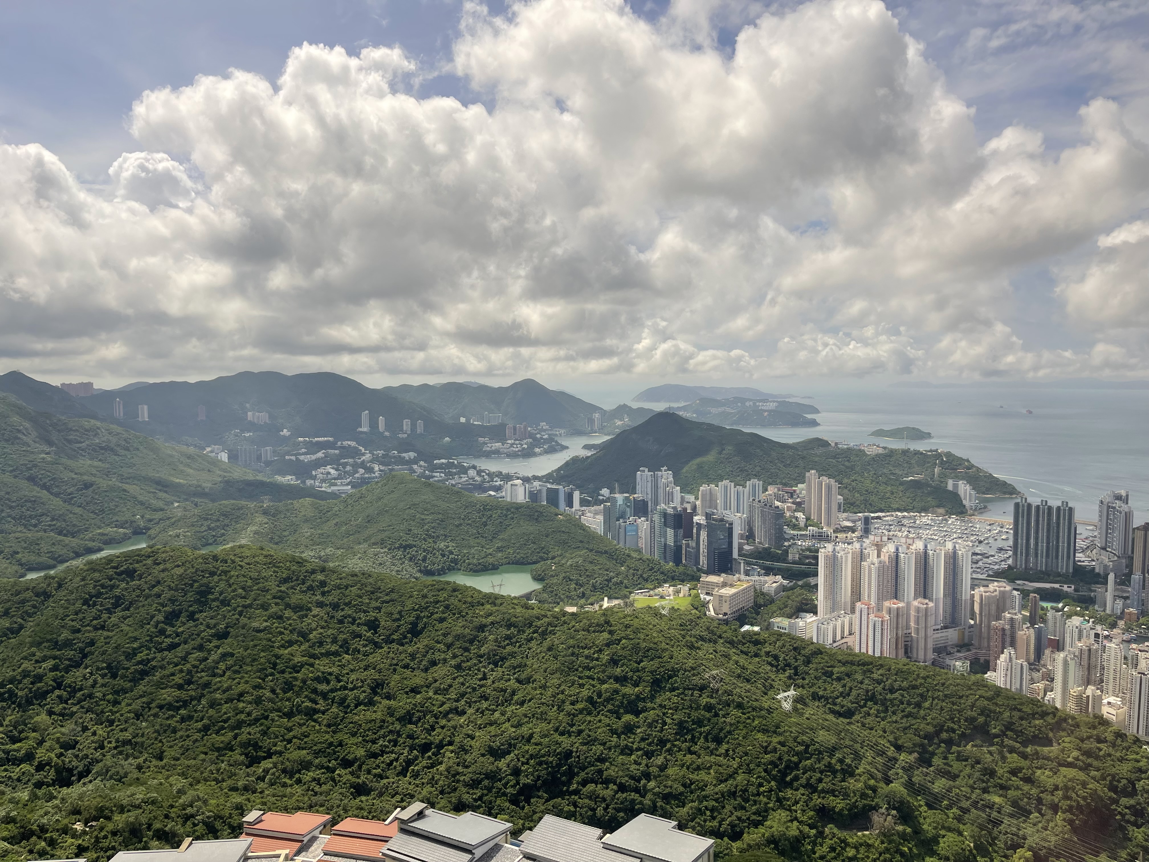 Looking southwest from the Peak in Hong Kong, across Wong Chuk Hang, and Aberdeen to Repulse Bay, Stanley, and the ocean, where container ships pass.