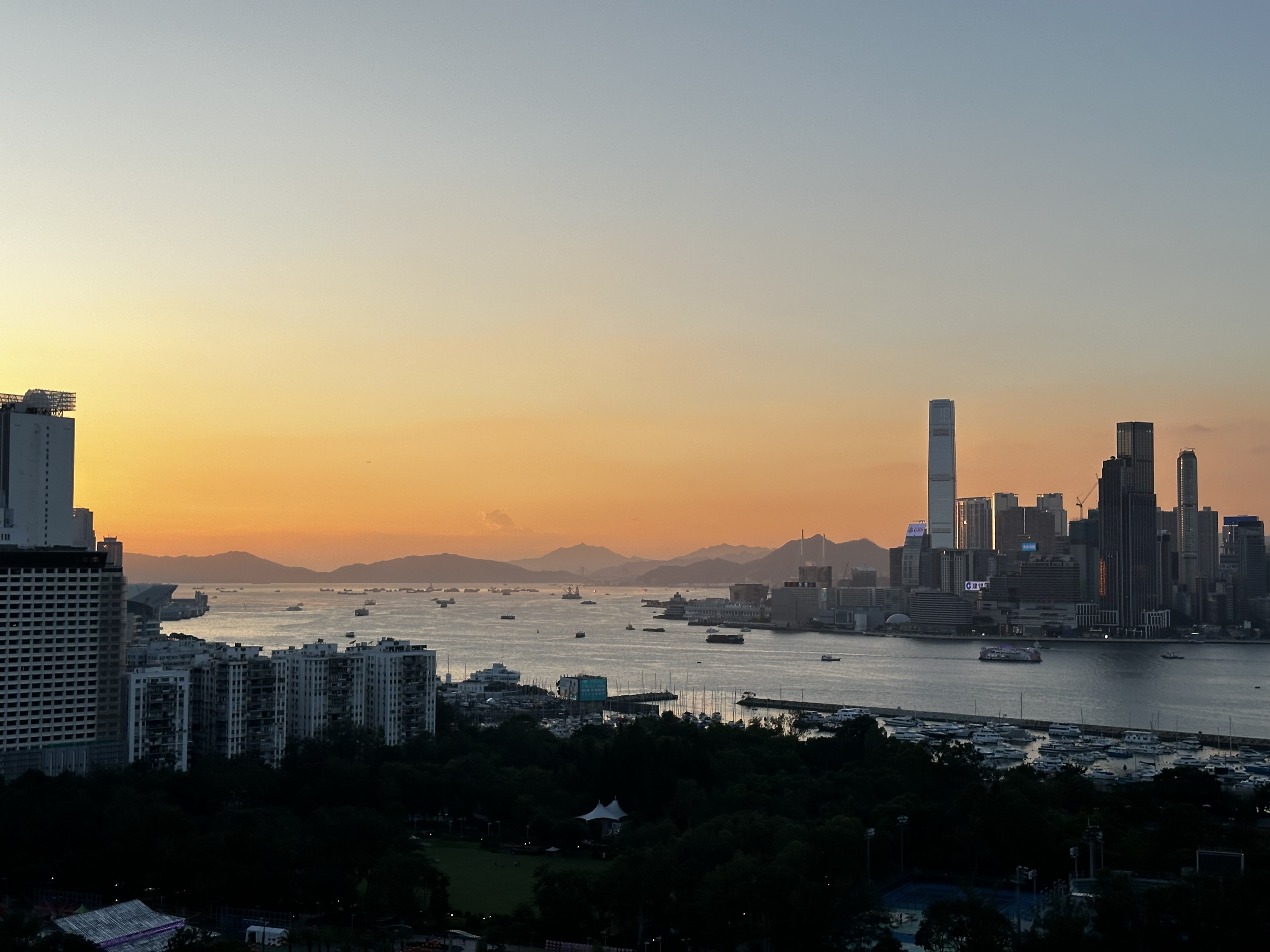 The sky fades at sunset over the harbor in Hong Kong, with TST in the foreground