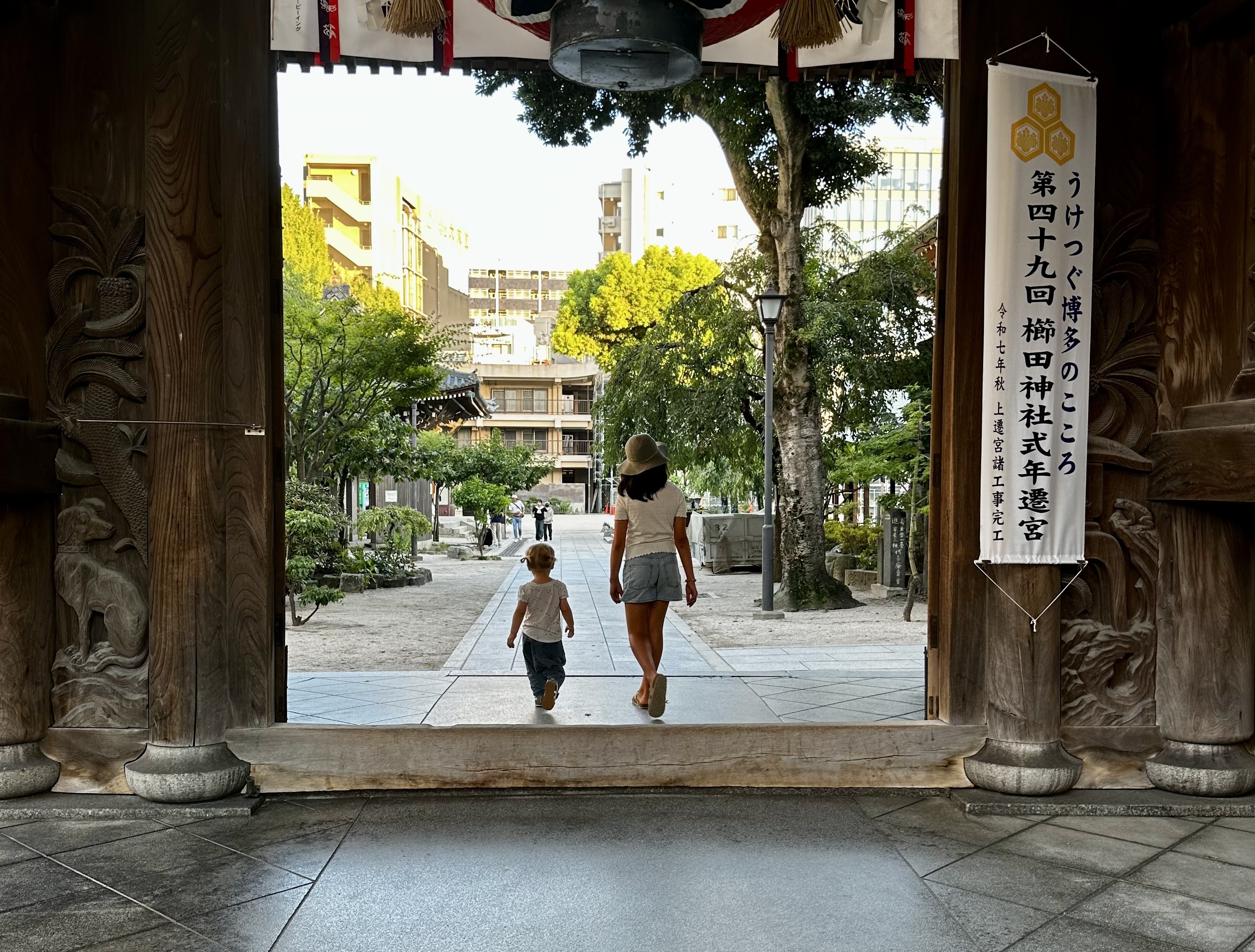 The youth of tomorrow today stepping through the doorway of a shrine in Fukuoka